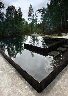 an empty pool surrounded by trees and water