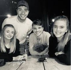 a group of people sitting around a wooden table