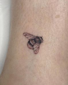 a small bee tattoo on the ankle