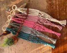 several different colored yarns and scissors sitting on a table next to a potted plant