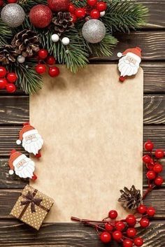 an old paper surrounded by christmas decorations and pine cones on a wooden background with space for text