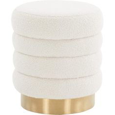 four white round cushions stacked on top of each other in front of a gold base