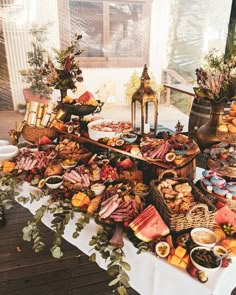 a table filled with lots of food on top of a wooden floor