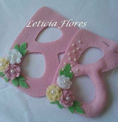 two pink masks with flowers and pearls on them