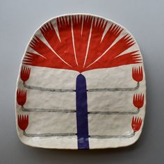 a red, white and blue plate with forks on it's rim is shown