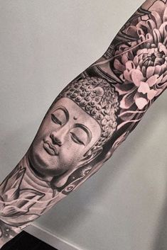 an arm tattoo with buddha and flowers on it