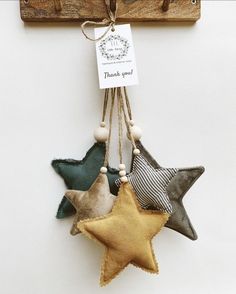 three star ornaments hanging from a wooden hook