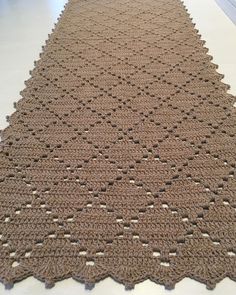 a crocheted rug is on the floor in a room with white walls and floors