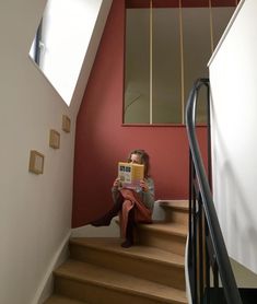 a woman sitting on the stairs reading a book