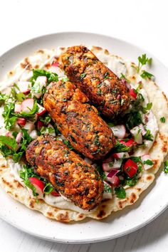 two chicken patties on top of a tortilla topped with fresh greens and radishes