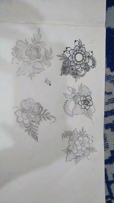 some flowers are drawn on a piece of white paper with blue and black designs in it