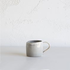 a white coffee cup sitting on top of a table