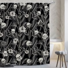 a black and white shower curtain with skulls and flowers in the background on a tile floor