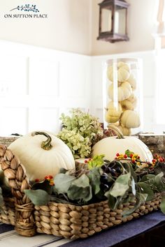 a basket filled with white pumpkins sitting on top of a table