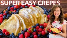 a woman holding a plate with fruit on it and the words super easy crepes