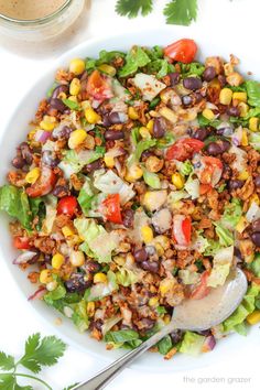 a white bowl filled with salad next to a spoon