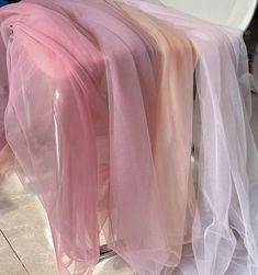 three different colored scarves hanging on a rack in front of a toilet and sink