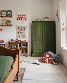 a child's bedroom with green cupboards and toys