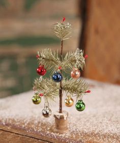 a small christmas tree sitting on top of a wooden table