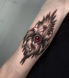 a woman with a tattoo on her arm has red eyes and an owl's head