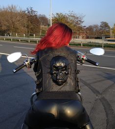 a woman with red hair on a motorcycle