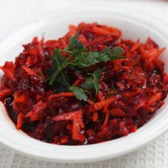 a white bowl filled with red food on top of a table