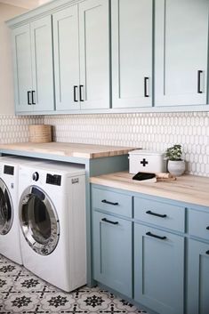 a washer and dryer in a kitchen with blue cabinets