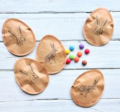 three brown paper bags with drawings of rabbits on them and candy in front of them