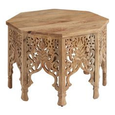 an octagonal wooden table with intricate carvings on the top and bottom, sitting against a white background