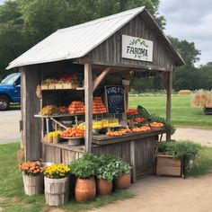 an outdoor produce stand with lots of fruits and vegetables on display in front of it