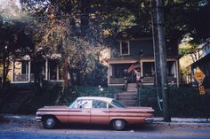 an old car parked in front of a house