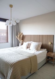 a bedroom with a large bed and wooden headboard on the wall next to a window