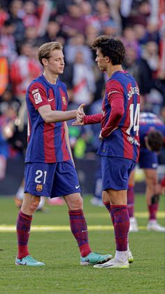 two soccer players shake hands on the field