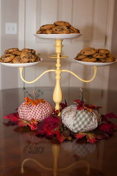 three tiered trays with cookies and pumpkins on them sitting on a table