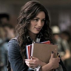 a woman is holding several folders in her hands