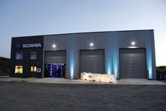 an industrial building with the word scania lit up at night