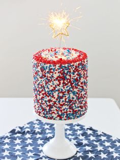 a red, white and blue cake with a sparkler on top