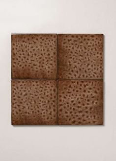 four square tiles with brown speckles arranged in the shape of rectangles