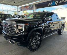 a black truck is parked in a showroom