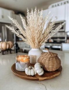 a tray with candles and some white pumpkins