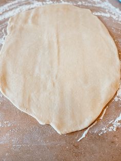 an uncooked pizza dough sitting on top of a table