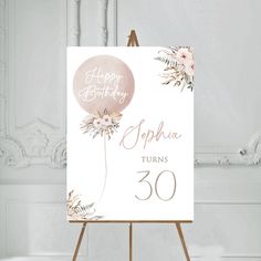 a birthday card on an easel with flowers and a balloon in the middle that says, happy birthday sophia turns 30