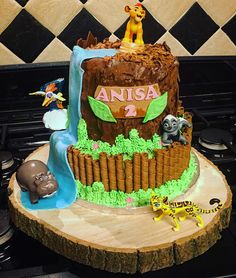 a birthday cake made to look like the lion king is on top of a tree stump