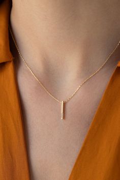 Our Solid Gold Diamond Vertical Bar Necklace is perfect for all classic lovers. It is indispensable for your jewelry box as it is magnificent and elegant. FEATURES * Made to order. * Gold KT: 14K * Gold Color Selection: Yellow Gold, Rose Gold, White Gold * Diamond Quality: Diamond carat: 0.02 ct. Cut: Perfect cut Diamond type: Zircon Setting Type: Prong Setting * Pendant Lamp Height: 15 mm / 0.59 inch * Pendant Width: 1 mm / 0.03 inch * Length: 14", 16", 18", 20" * Ready to Ship in 1-3 Business Luxury Yellow Gold Bar Necklace For Women, Gold Bar Pendant, Gold Face Mask, Heartbeat Necklace, Gold Leaf Necklace, Diamond Bar Necklace, Vertical Bar Necklace, Vertical Bar, Gold Face