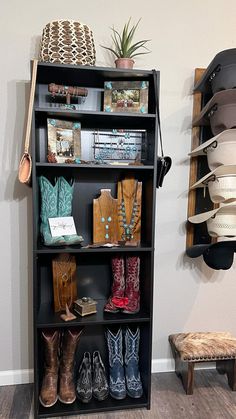 a book shelf with boots and hats on it next to a wall mounted potted plant