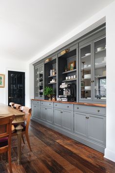 a dining room with wooden floors and gray cabinets