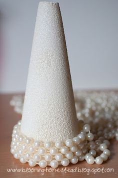 a white hat with pearls around it on a table