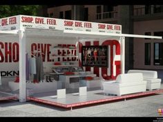 a white booth with red lettering on the front and side walls that says shop give feed