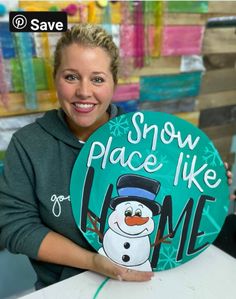 a woman holding up a snow place like sign