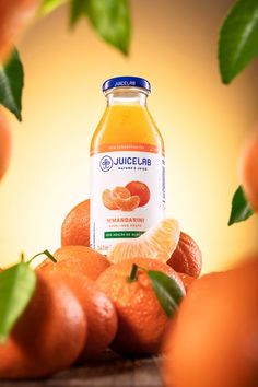 a bottle of juice sitting on top of oranges